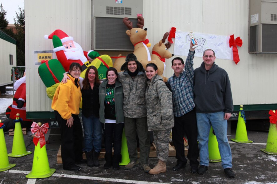 After emerging victorious in the 2010 Operations Group Holiday decorating competition, members of the 911th  Aeromedical Evacuation Squadron proudly pose with Wing Commander, Col. Jeffery T. Pennington (center), as James Wise, Customer Support Technician, triumphantly hoists their new trophy.  The 911th Operations Group held the competition as a team and morale building exercise allowing members to embrace their alternate work centers, while their operations building undergoes renovations.