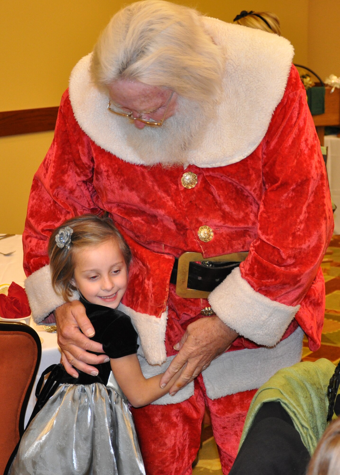 Santa Claus visits with seven-year-old Trinity, daughter of a deployed Airman, during the Hearts Apart annual holiday party Dec. 15 at the Soundside Club at Hurlburt Field, Fla. Throughout the year, the program sponsors a series of monthly gatherings for spouses and children of deployed members. (DoD photo by U.S. Airman 1st Class Joe McFadden / RELEASED) 