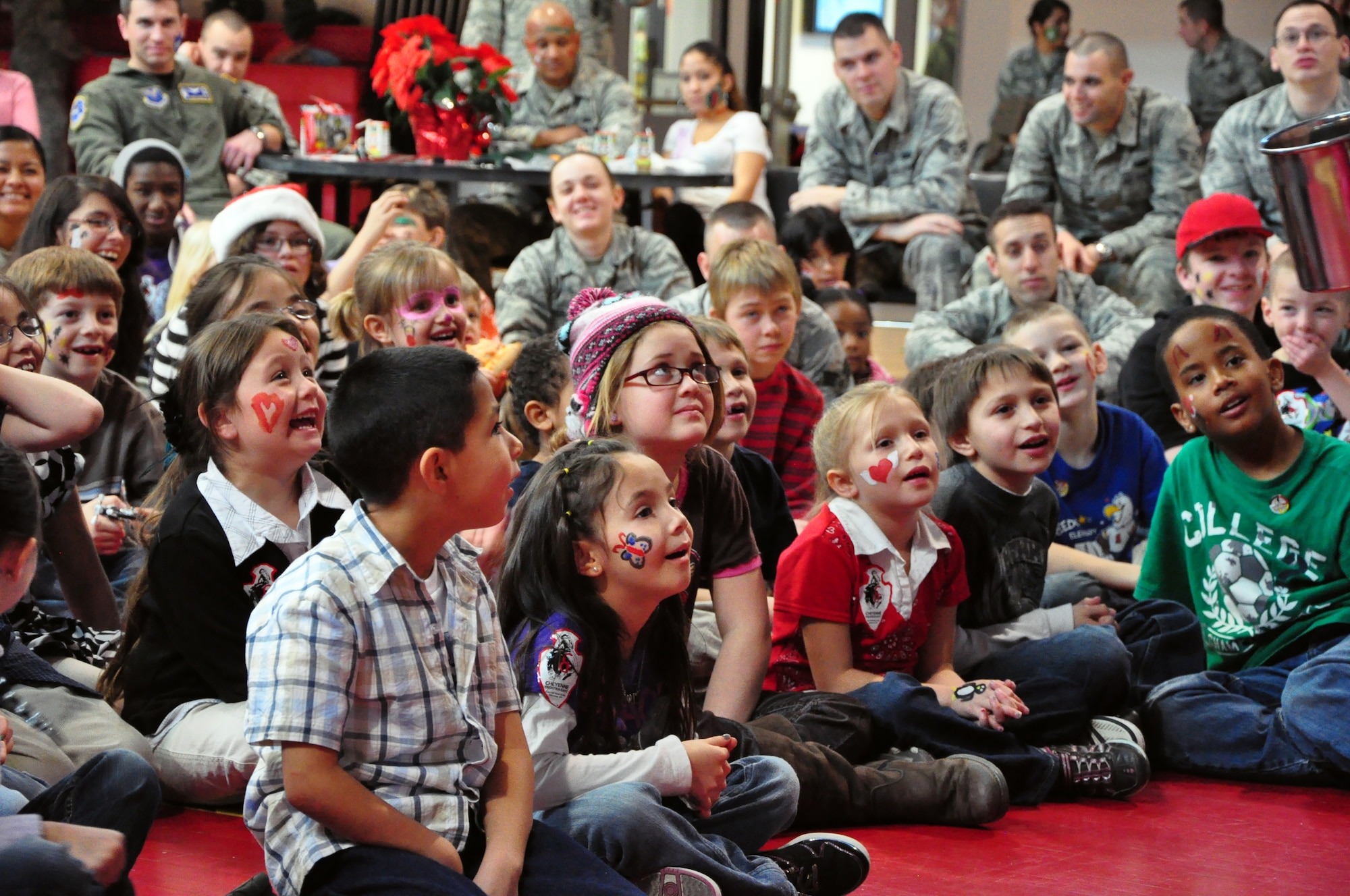 A group of children from the Cheyenne community enjoy a magician performance for Operation Provide Joy in the Fall Hall Community Center on Dec. 11. (U.S. Air Force photo by Staff Sgt. Chad Thompson)