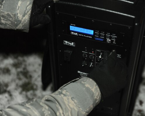RAF MILDENHALL, England -- Tech Sgt. Shannon Smith, 100th Communications Squadron radio frequency transmission systems supervisor, adjusts the settings on a public address system during the Christmas Tree Lighting here Dec. 3, 2010. To ensure audiences can hear the speakers, PA systems are used at commander's calls, military ceremonies and base events. (U.S. Air Force photo/Senior Airman Tabitha M. Lee)
