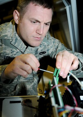 RAF MILDENHALL, England -- Staff Sgt. Andrew Lee, 100th Communications Squadron radio frequency transmission systems supervisor, fixes a node here Dec. 1, 2010.  A node allows the giant voice to receive and emit messages to the speakers attached to it.  (U.S. Air Force photo/Senior Airman Tabitha M. Lee)