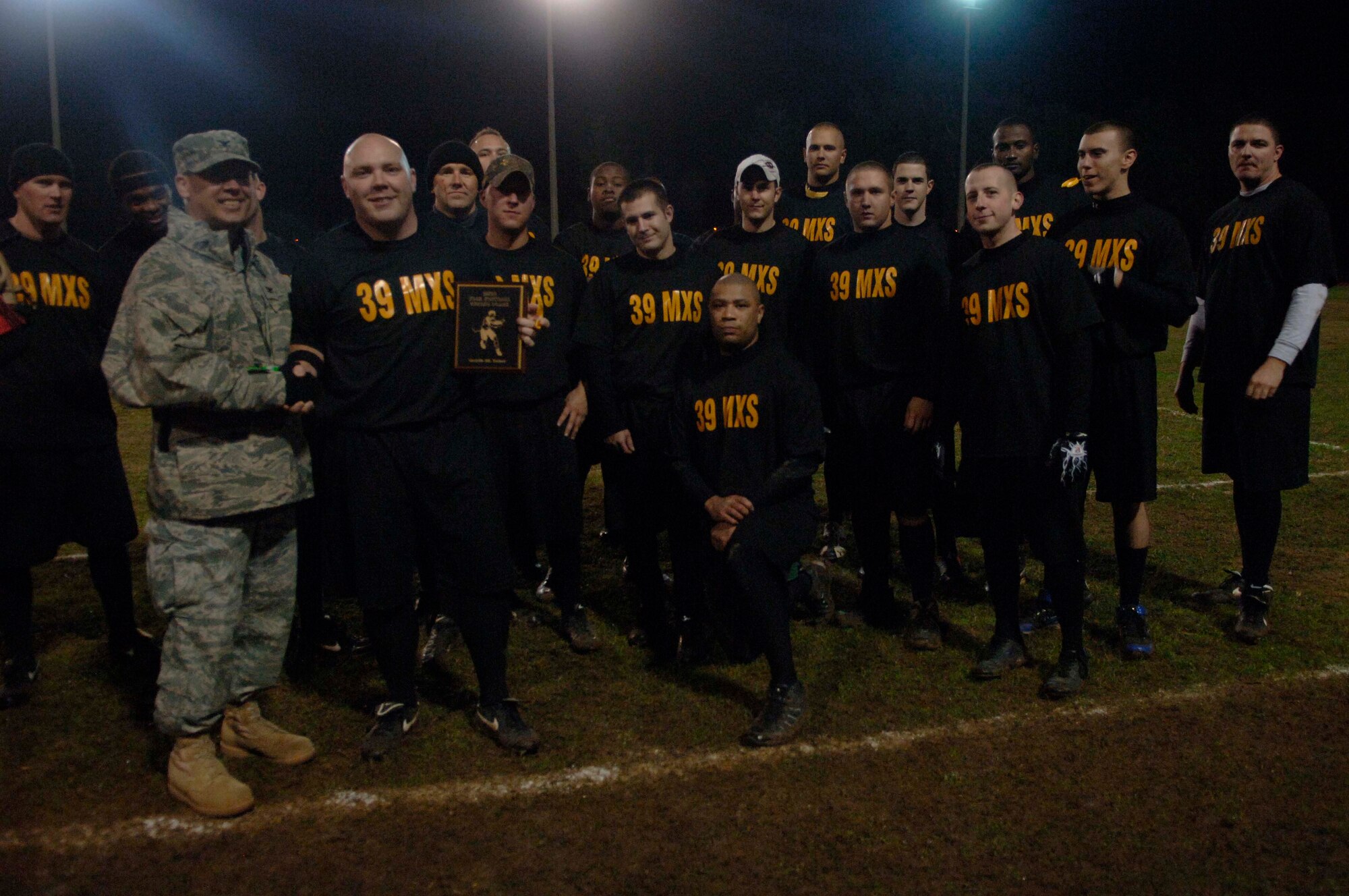 Col. Anthony Butts, the 39th Air Base Wing vice commander, rewards the 39th Maintenance Squadron a plaque for finishing the Incirlik flag football season in second place. MXS lost to the 39th Security Forces Squadron 34-6 in the championship game Dec. 13, at Incirlik Air Base, Turkey.  (U.S. Air Force photo by Senior Airman Ashley Wood/Released)