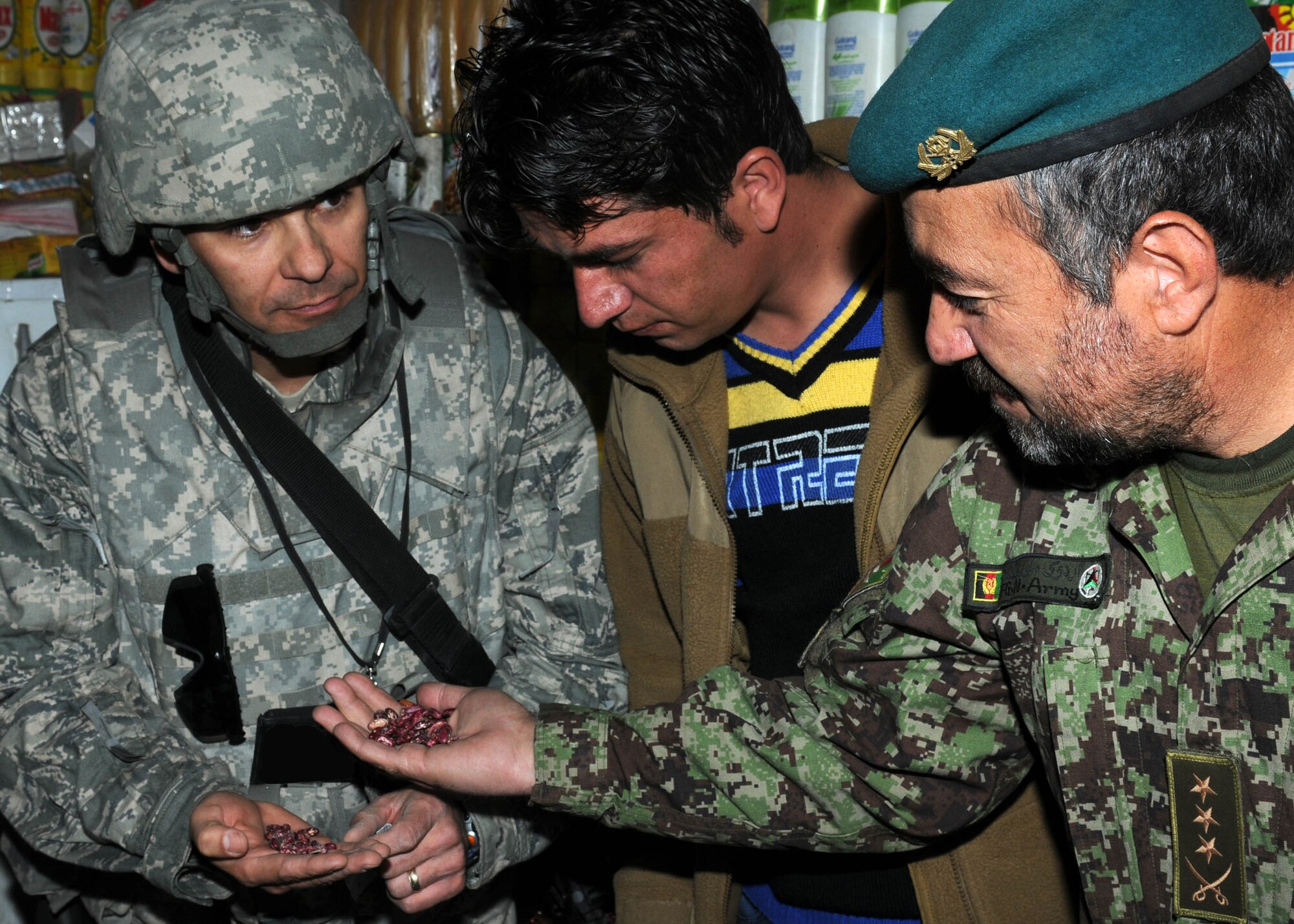 101121-N-6541W-010 KABUL, Afghanistan - Maj. David Burnett (left), the Afghan Air Force Religious and Cultural Affairs Advisor with NATO Training Command-Afghanistan and an Afghan Air Force officer inspect beans that will be passed out in the coming weeks on the Afghan Air Force Base in Kabul.  (U.S. Navy photo by Mass Communication Specialist 3rd Class Jared Walker/ RELEASED).