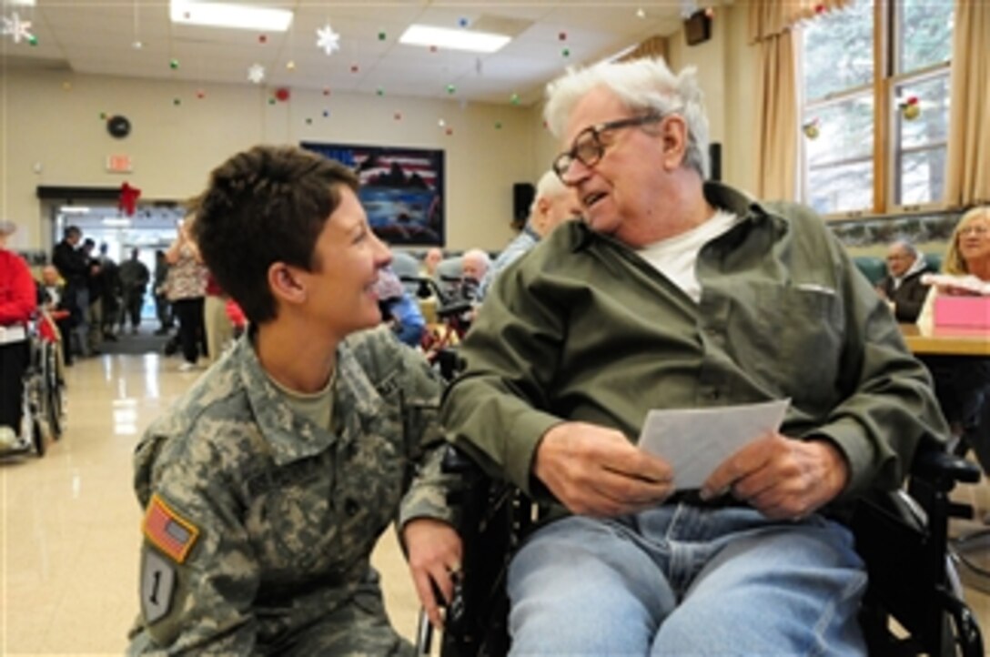 U.S. Army Staff Sgt. Amy Wieser Willson (left), with the 231st Brigade Support Battalion, North Dakota National Guard, visits with a resident of the North Dakota Veterans Home in Lisbon, N.D., during the annual Christmas party on Dec. 15, 2010.  