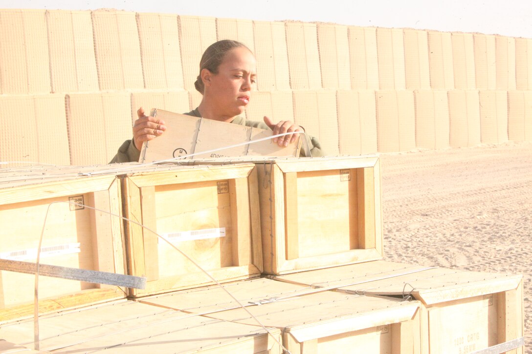 Lance Cpl. Jasmine I. Vazquez, ammunition technician, Supply Company, Combat Logistics Regiment 15 (Forward), 1st Marine Logistics Group (Forward), picks up an ammunition crate at the Field Ammunition Supply Point at Camp Bastion, Afghanistan, Dec. 21. The Marines who work at the FASP provide all types of ammunition and explosives to coalition forces in southwestern Afghanistan.