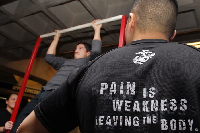 Pfc. Brittany Dexter, 19, from Blaine, Minn., and Sgt. Dae Kim, 25, from Stockton, Calif., motivate Alex Dubois, a 22-year-old attending Brigham Young University, during the pull-up challenge at the Target Center Dec. 22 where the Minnesota Timberwolves took on the Utah Jazz. Dexter is currently serving as a recruiter's assistant at Coon Rapids and Kim is a recruiter out of the Woodbury office.