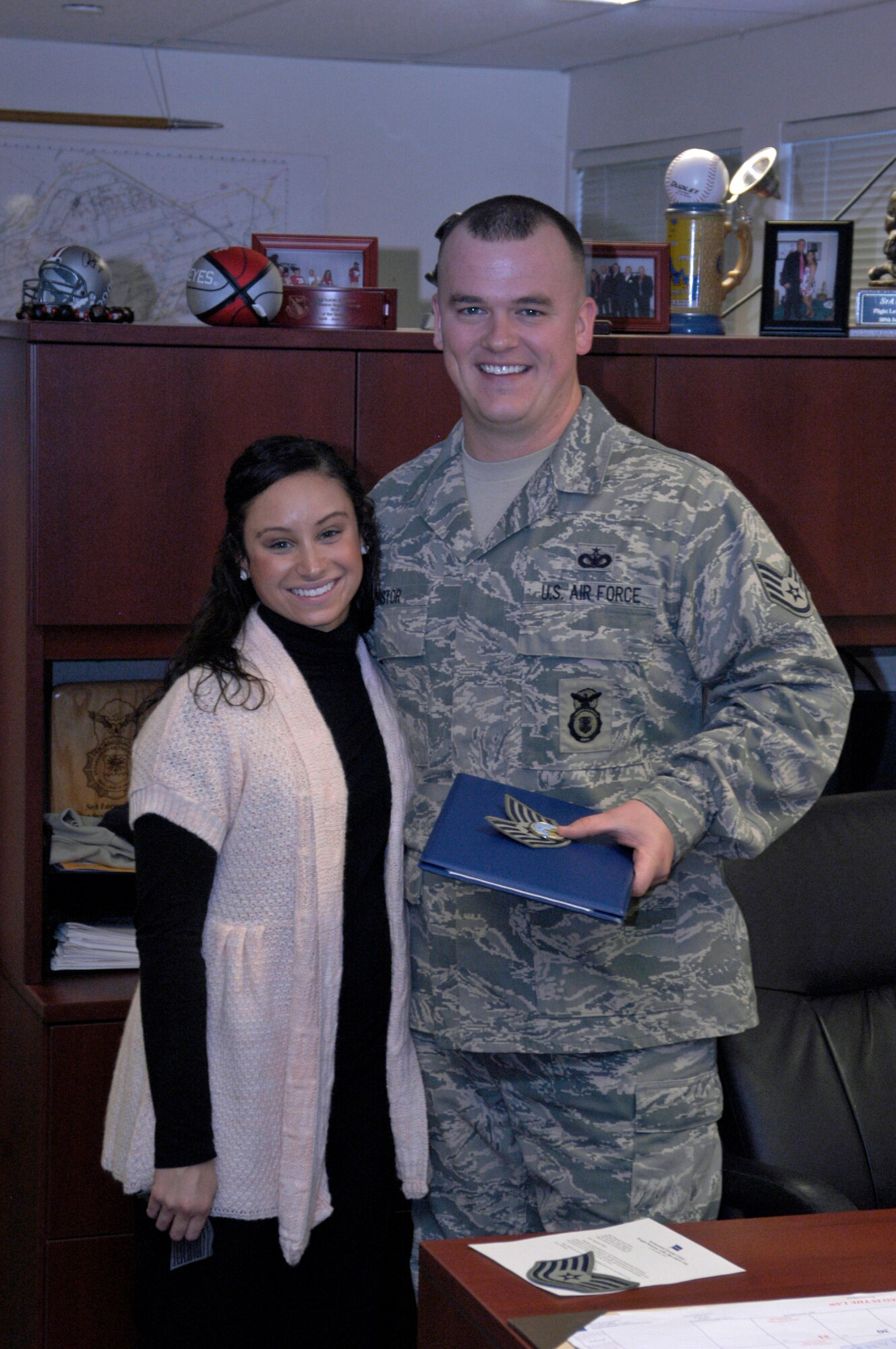 Staff Sgt. Luke Bistor of the 88th Security Forces Squadron gets a hug of congratulations from his wife, Brandy, following his surprise promotion to Technical Sgt. Dec. 21, 2010 at Wright-Patterson Air Force Base, Ohio.  Lt. Gen. Thomas Owen, commander of Aeronautical Systems Center, promoted Sergeant Bistor via the Stripes for Exceptional Performers program. Sergeant Bistor is from Cambridge, Ohio. (U.S. Air Force photo/Derek Kaufman)
