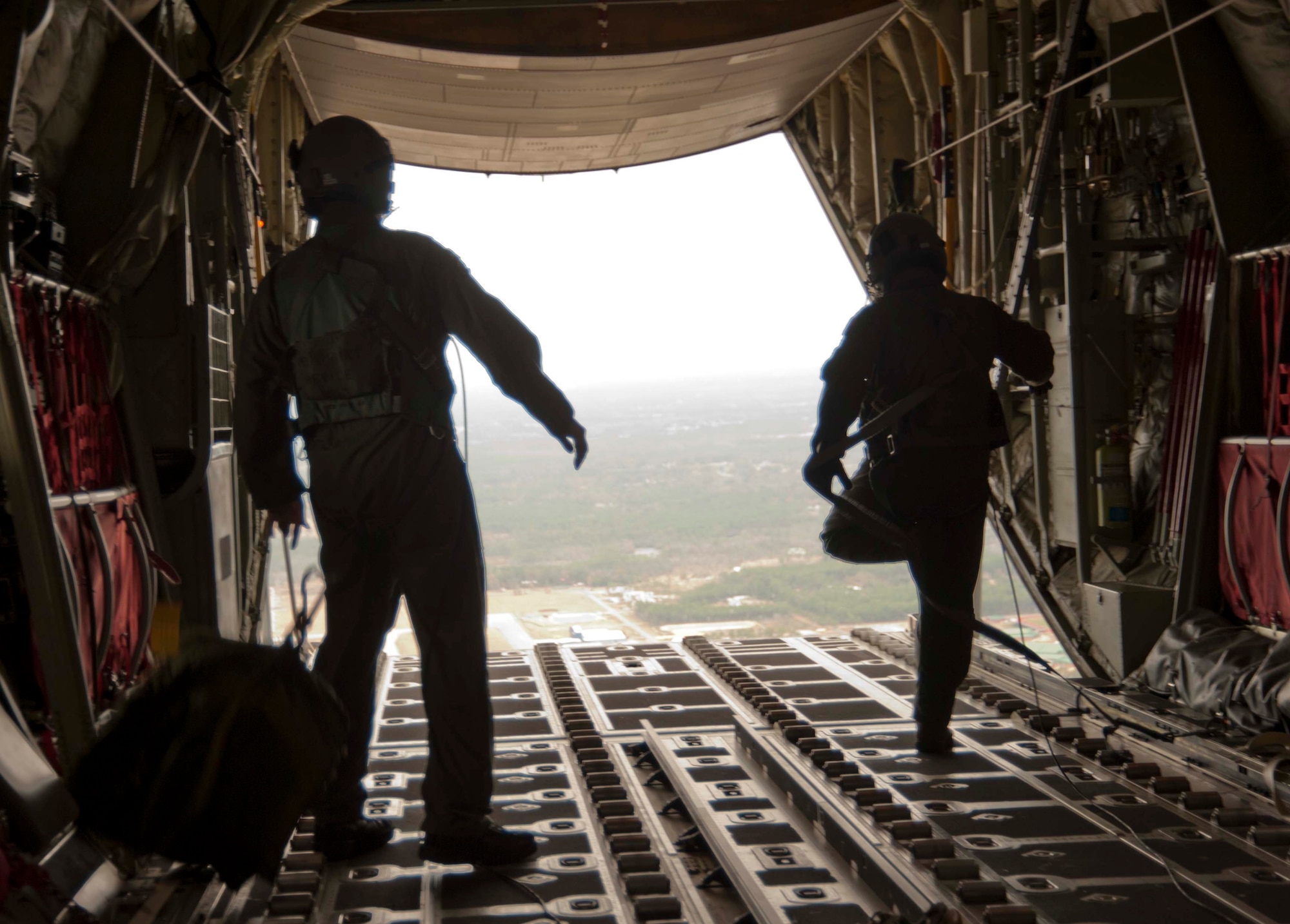 Loadmasters race to raise the cargo bay ramp after airdropping simulated cargo from the back of their C-130J-30 model aircraft. Tech. Sgts. Dana Kelley (right) and Ricky Jackson serve with the 815th and 345th Airlift Squadrons, respectively. The 815th "Flying Jennies" and 345th "Golden Eagles," an active associate unit, train side-by-side preparing for an upcoming deployment early next year in support of overseas contingencies in Southwest Asia. (U.S. Air Force photo by Tech. Sgt. Ryan Labadens)