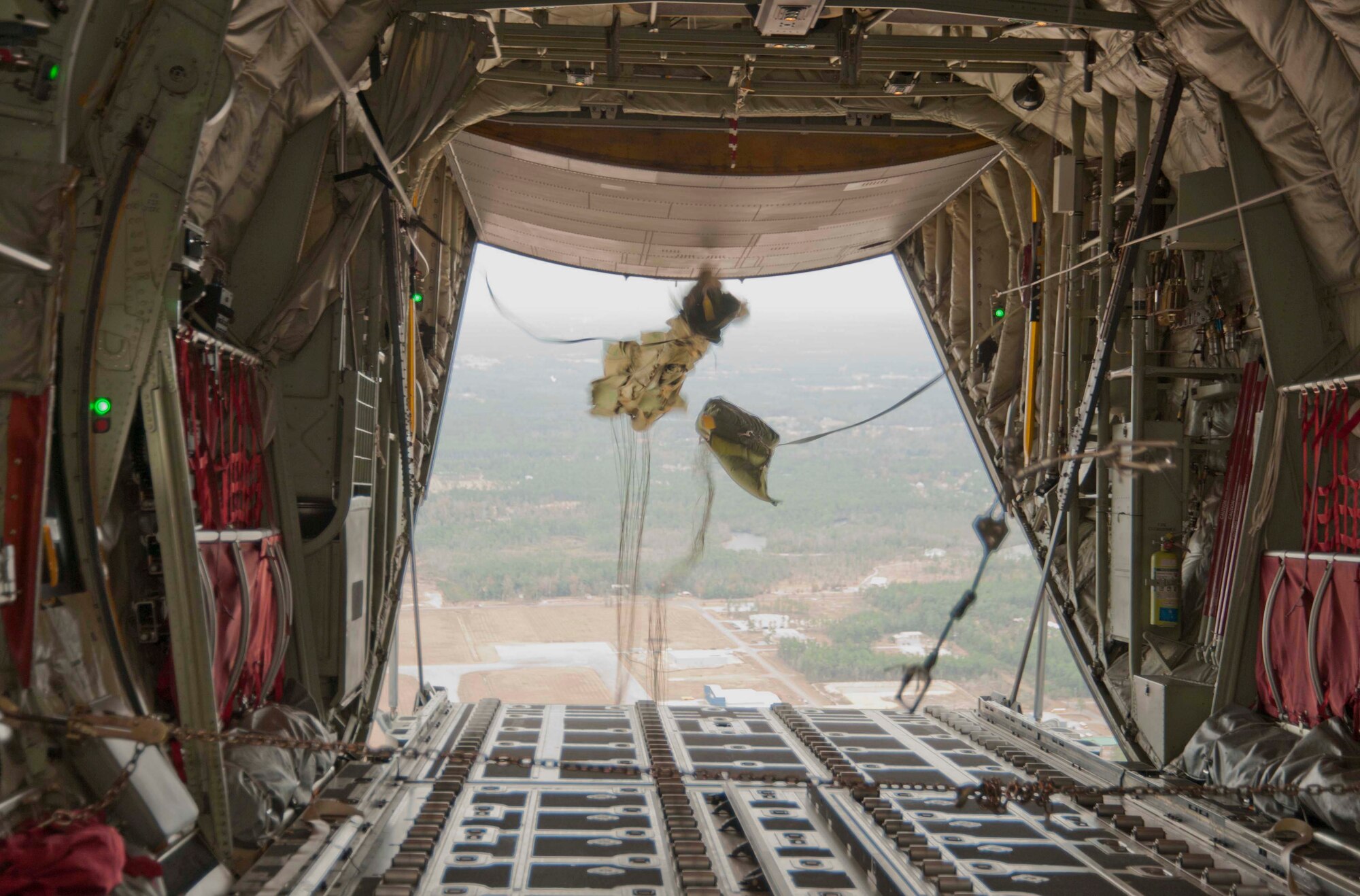 Parachutes deploy on simulated cargo airdropped from a C-130J-30 stretch model flown by Reservists with the 815th Airlift Squadron and active-duty members from the 345th AS. This was part of the squadrons' training for an upcoming deployment early next year in support of overseas contingencies in Southwest Asia. The 815th "Flying Jennies" and 345th "Golden Eagles," an active associate unit, work and train side-by-side as part of the 403rd Wing at Keesler Air Force Base, Miss. (U.S. Air Force photo by Tech. Sgt. Ryan Labadens)