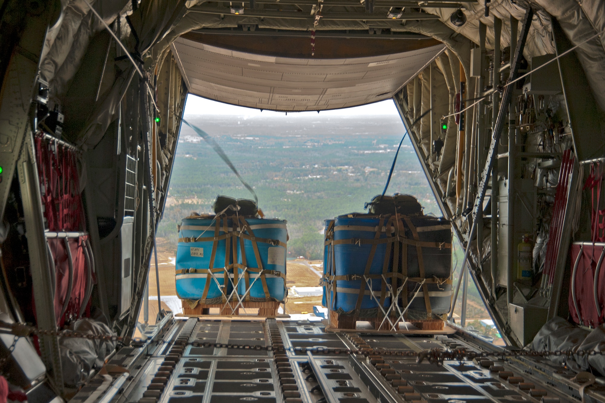 Water barrels roll out the back of a C-130J-30 stretch model aircraft flown by Reservists with the 815th Airlift Squadron and active-duty members from the 345th AS. This airdrop was part of the squadrons' training for an upcoming deployment early next year in support of overseas contingencies in Southwest Asia. The 815th "Flying Jennies" and 345th "Golden Eagles," an active associate unit, work and train side-by-side as part of the 403rd Wing at Keesler Air Force Base, Miss. (U.S. Air Force photo by Tech. Sgt. Ryan Labadens)