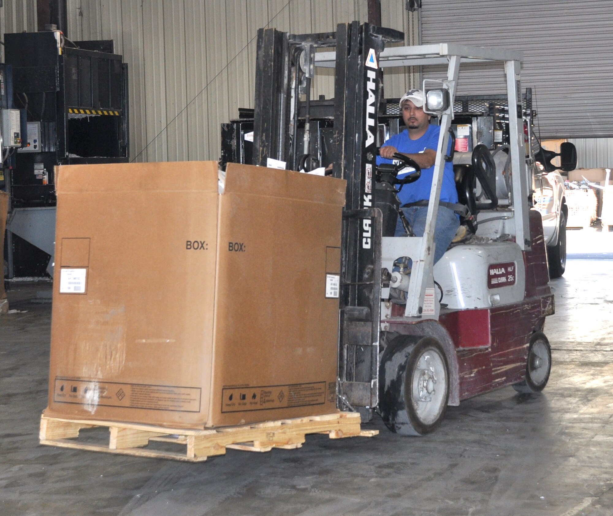 George Ramirez, a recycling center associate at Laughlin Air Force Base, Texas, drives a fork lift with a box of outdated flight manuals and publications. The documents are loaded onto a truck and driven to San Antonio, where they can be processed for recycling. (U.S. Air Force photo/ 2nd. Lt. Angela Martin)