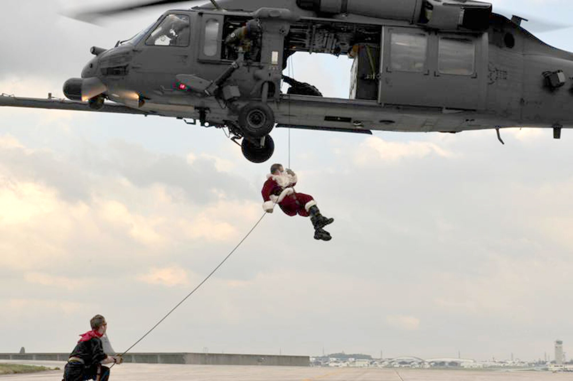 Santa Claus, with an assist from one of his elves, rappels from an HH-60 Pave Hawk Dec. 17, 2010, to greet children of the 31st and 33rd Rescue Squadrons at Kadena Air Base, Japan. Santa wasn't the only attraction at this year's squadron celebration. There were games, cake decorating and other events. (U.S. Air Force photo/Staff Sgt. Lakisha Croley)
