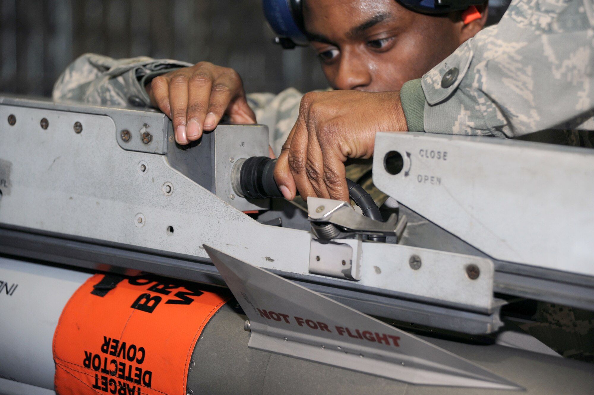 Staff Sgt. Rodney Akins connects an umbilical cable to a missile launcher Dec. 17, 2010, at Misawa Air Base, Japan, during the wing load crew competition. During the competition, the Airmen are graded on a variety of areas including, speed, accuracy, appearance and safety. Sergeant Akins is a weapons load crewmember with the 35th Maintenance Squadron. (U.S. Air Force photo/Tech. Sgt. Russell McBride)