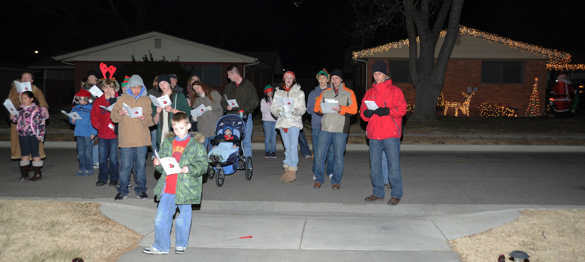 Team McConnell Airmen and family members sing holiday carols for Southwind Base Housing residents Dec. 19, 2010, McConnell Air Force Base, Kan. The base chapel hosted the second Annual McConnell Base Housing Christmas caroling event, with more than 60 members participating. (U.S. Air Force photo/Senior Airman Maria A. Ruiz)