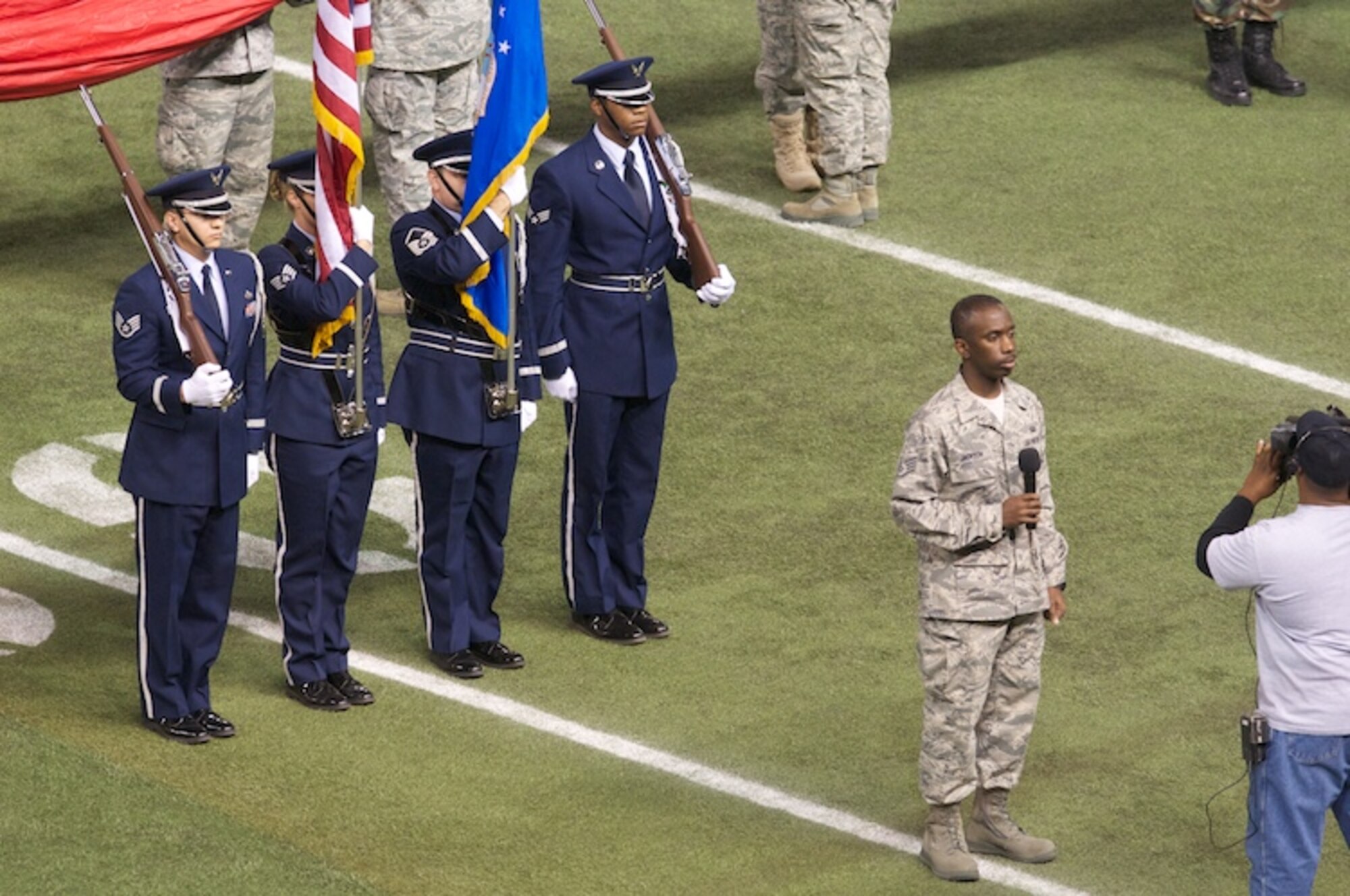 Honor Guard members of the 6th Air Mobility Wing and the 927th Air Refueling Wing present the colors while Staff Sergeant Anthony Jackson sings the national anthem during the opening ceremonies of the Beef O' Brady's Bowl (Photo by Steve Johnson courtesy of ESPN)
