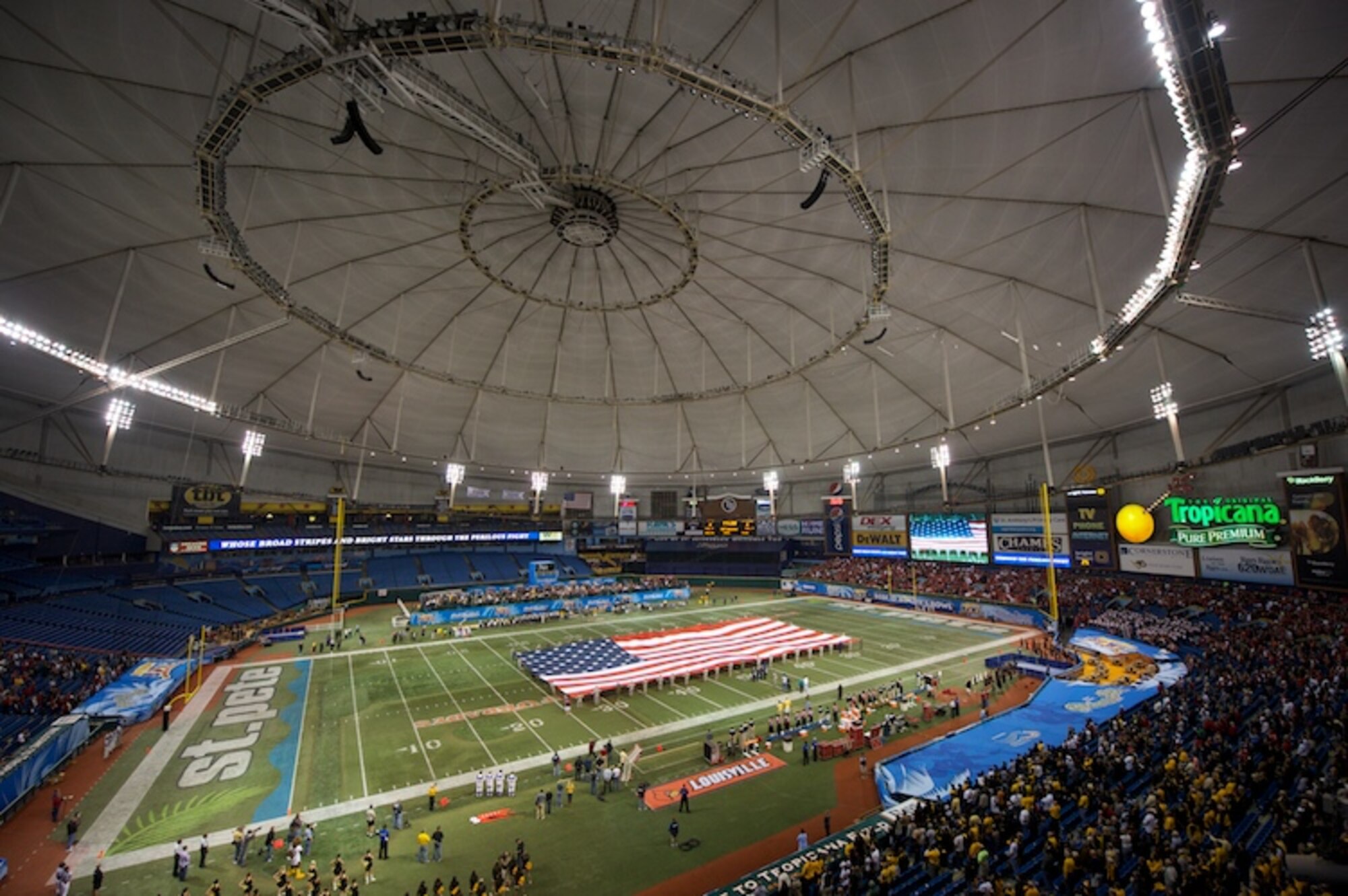 Active duty, National Guard, and Reserve members out of MacDill Air Force Base present a giant U.S. flag during the opening ceremonies of the Beef O' Brady's Bowl at Tropicana Field, St. Petersburg. (Photo by Steve Johnson courtesy of ESPN)