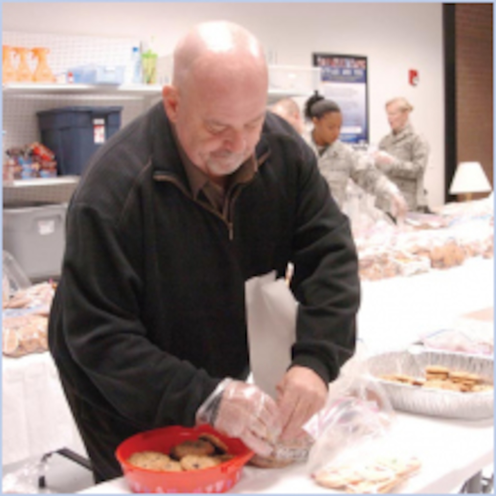 Community volunteers came to help Team Hill at the Airman and Family Readiness Center on Dec. 17. Layton Mayor Steve Curtis bags cookies. (U.S. Air Force photo by A1C Melissa Dearstone)