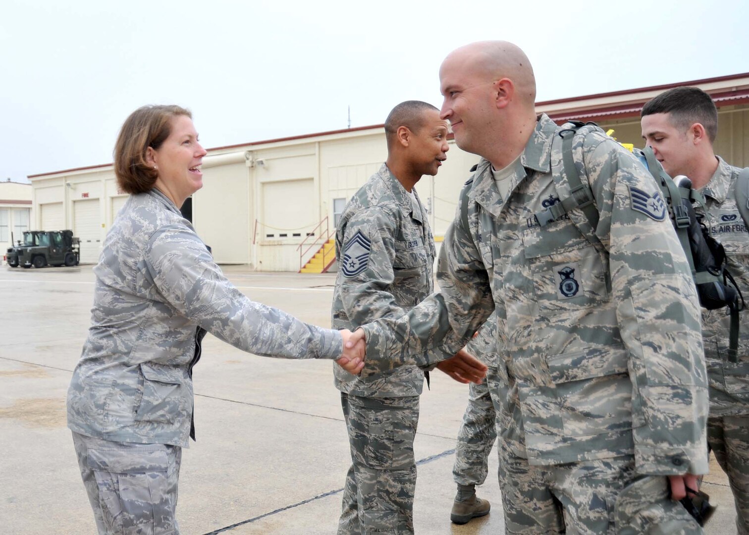 Lt. Col. Kara Neuse, 802nd Mission Support Group deputy commander, shakes hands with Staff Sgt. Alan Dupuis before he boards a plane at Lackland's Kelly Field Annex flightline Dec. 22. Sergeant Dupuis, 802nd Security Forces Squadron, is among more than 45 Airmen from Lackland, Goodfellow, Dyess and Randolph Air Force Bases deploying to Iraq in support of Operation New Dawn. (U.S. Air Force photo/Alan Boedeker)