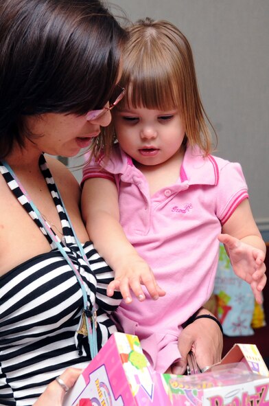 Nanci Campbell and her daughter Delilah Campbell, 2, look at Christmas gifts during the toy giveaway at the Chapel 2 Annex on Barksdale Air Force Base, La., Dec. 22. The toy giveaway was for Airmen E-4 and below who needed a little help with Christmas. (U.S. Air Force photo/Senior Airman Brittany Y. Bateman)(RELEASED) 