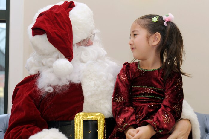 Calista Russell sits on Santa's lap as she tells him what she wants for Christmas during the children of deployed members holiday party held at the chapel annex Dec. 18, 2010, on Joint Base Charleston, S.C. The holiday party was held by the Honorary Commanders Advisory Council with gifts and food supplied by local businesses. Calista is the daughter of Tech. Sgt. Christopher Russell, assigned to the 437th Aircraft Maintenance Squadron. (U.S. Air Force photo/Staff Sgt. Marie Brown)