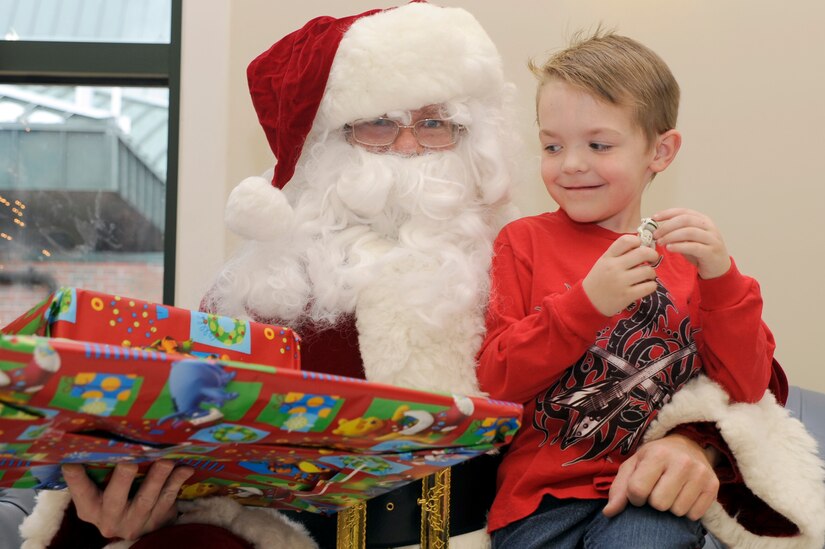 Brayden Crerar sits on Santa's lap as he waits for Santa to give him his Christmas present during the children of deployed members holiday party held at the chapel annex Dec. 18, 2010, on Joint Base Charleston, S.C. The holiday party was held by the Honorary Commanders Advisory Council with gifts and food supplied by local businesses. Brayden is the son of Tech. Sgt. Tony Crerar, assigned to the 437th Aircraft Maintenance Squadron. (U.S. Air Force photo/Staff Sgt. Marie Brown)