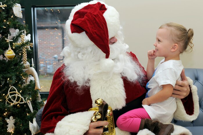 Kayden Green sits on Santa's lap as she tells him what she wants for Christmas during the children of deployed members holiday party held at the chapel annex Dec. 18, 2010, on Joint Base Charleston, S.C. The holiday party was held by the Honorary Commanders Advisory Council with gifts and food supplied by local businesses. Kayden is the daughter of Staff Sgt. David Green, assigned to the 437th Aircraft Maintenance Squadron. (U.S. Air Force photo/Staff Sgt. Marie Brown)