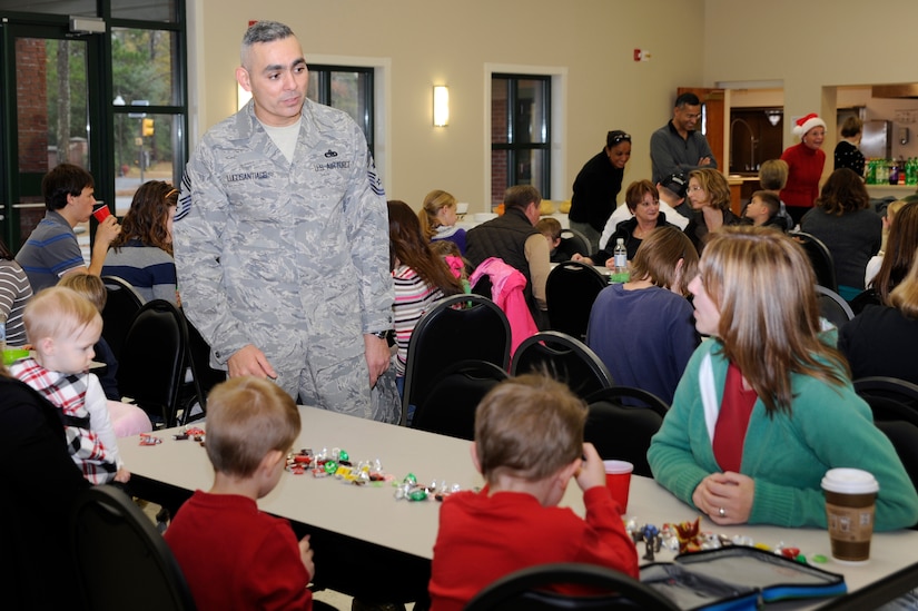 Chief Master Sgt. Jose LugoSantiago talks with children and spouses of deployed members while they await the arrival of Santa during the children of deployed members holiday party held at the chapel annex Dec. 18, 2010, on Joint Base Charleston, S.C. The holiday party was held by the Honorary Commanders Advisory Council with gifts and food supplied by local businesses. Chief LugoSantiago is the 628th Air Base Wing command chief. (U.S. Air Force photo/Staff Sgt. Marie Brown)