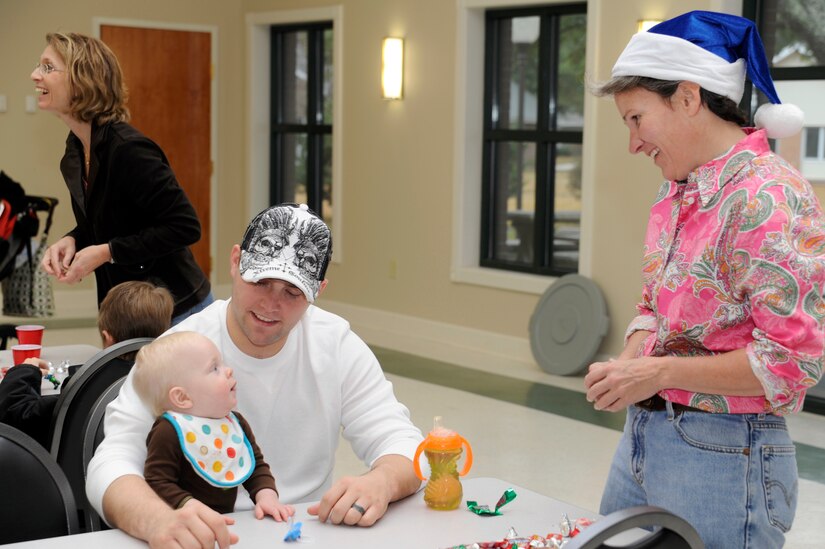 Col. Martha Meeker talks with Senior Airman Stefan Adams and his son Aiden as they await the arrival of Santa during the children of deployed members holiday party held at the chapel annex Dec. 18, 2010, on Joint Base Charleston, S.C. The holiday party was held by the Honorary Commanders Advisory Council with gifts and food supplied by local businesses. Colonel Meeker is the JB CHS commander, and Airman Adams is assigned to the 437th Operations Support Squadron. (U.S. Air Force photo/Staff Sgt. Marie Brown)