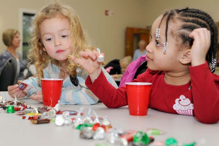 Layla Ragland, left, and Krista Cheatham pick out a piece of candy as they await the arrival of Santa during the children of deployed members holiday party held at the chapel annex Dec. 18, 2010, on Joint Base Charleston, S.C. The holiday party was held by the Honorary Commanders Advisory Council with gifts and food supplied by local businesses. Layla is the daughter of Master Sgt. Earl Ragland, assigned to the 628th Logistics Readiness Squadron, and Krista is the granddaughter of Rose Alexander, assigned to the 628th Air Base Wing public affairs office. (U.S. Air Force photo/Staff Sgt. Marie Brown)