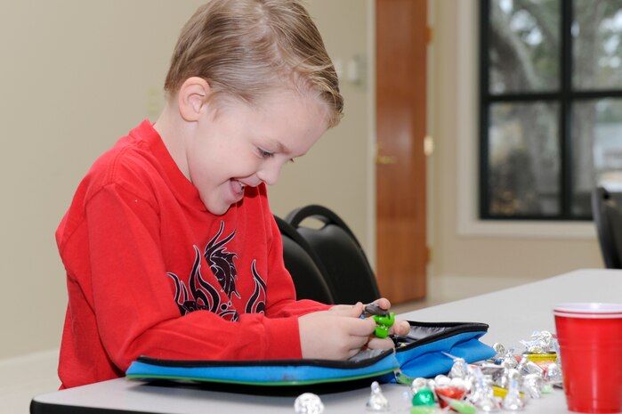 Brayden Crerar plays with his toys as he awaits the arrival of Santa during the children of deployed members holiday party held at the chapel annex Dec. 18, 2010, on Joint Base Charleston, S.C. The holiday party was held by the Honorary Commanders Advisory Council with gifts and food supplied by local businesses. Brayden is the son of Tech. Sgt. Tony Crerar, assigned to the 437th Aircraft Maintenance Squadron. (U.S. Air Force photo/Staff Sgt. Marie Brown)