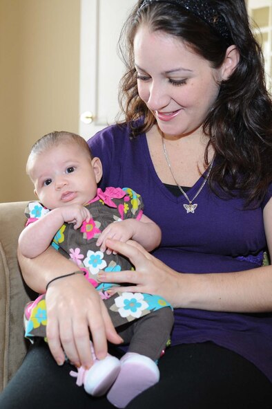 Capt. Leria Diaz holds her 7 week-old daughter Valeria in the living room of the Andrews Air Force Base, Md. Fisher House. Valeria and her parents are guests at the facility, while she receives specialized medical treatment in the National Capital Region. (U.S. Air Force Photo by Tech. Sgt. Chyenne A. Adams)