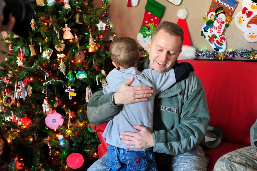 Master Sgt. Drue Titensor, 419th Aircraft Structural Maintenance supervisor, gets a hug at the home of a foster family as he delivers gifts Dec. 15. (U.S. Air Force photo/Kim Cook)