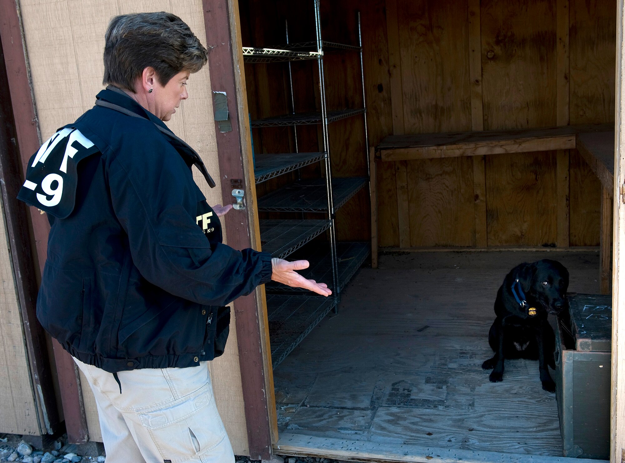 Lauren Marakas questions Ruthie to find where explosives are hidden Dec. 16, 2010, at Nellis Air Force Base, Nev., during a joint explosive detection training exercise. Mrs. Marakas is a senior special agent canine handler from the Bureau of Alcohol, Tobacco, Firearms, and Explosives, and Ruthie is an explosives detection canine. (U.S. Air Force photo/Senior Airman Brett Clashman)