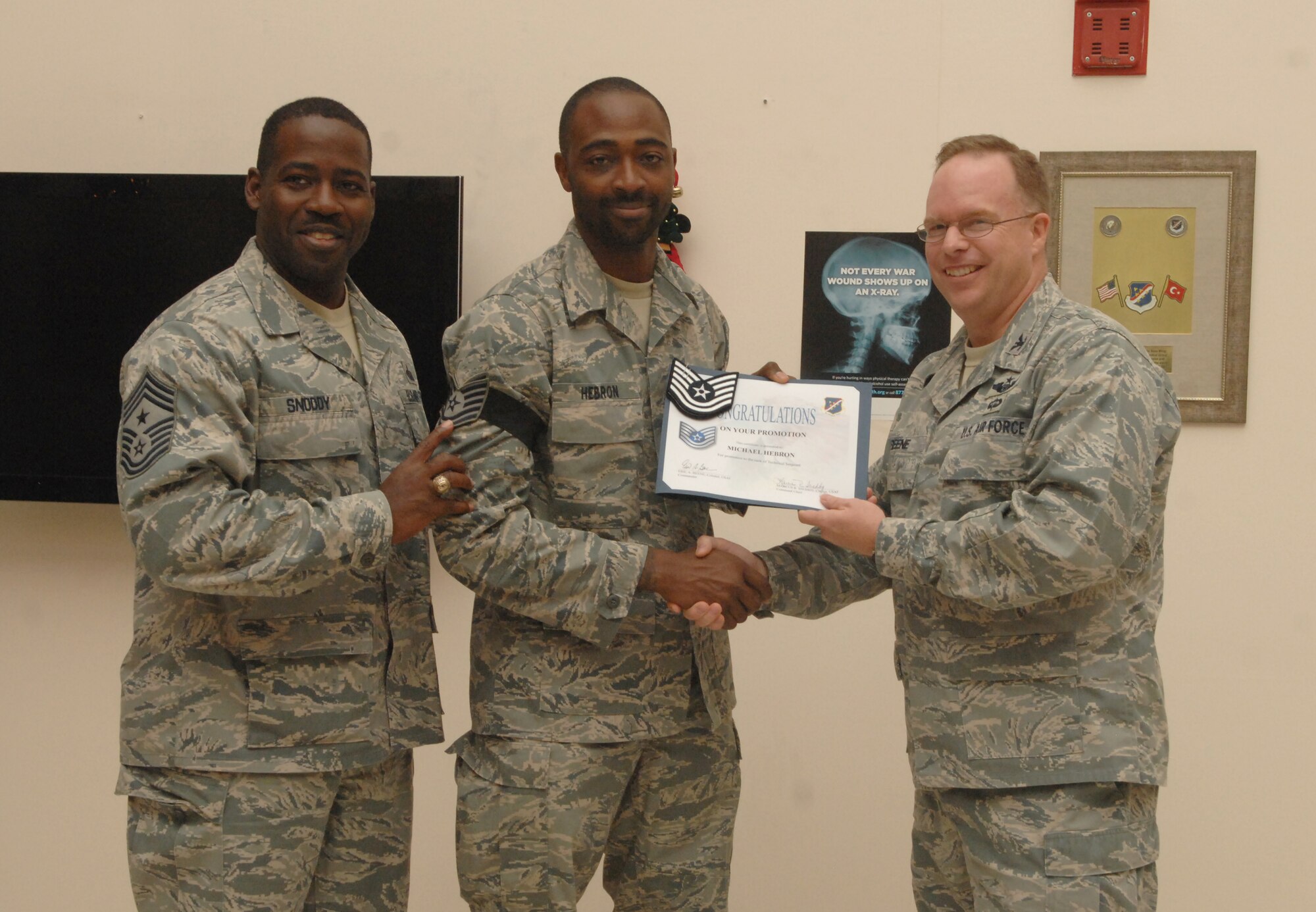 Col. Eric Beene, the 39th Air Base Wing commander and Chief Master Sgt. Marcus Snoddy, the 39th Air Base Wing command chief, promote Staff Sgt. Michael Hebron to technical sergeant in a surprise ceremony Dec. 22, at Incirlik Air Base, Turkey.  Sergeant Hebron was promoted through the Stripes for Exceptional  Performers program. (Photo by Tech. Sgt. Valda Wilson/ Released)