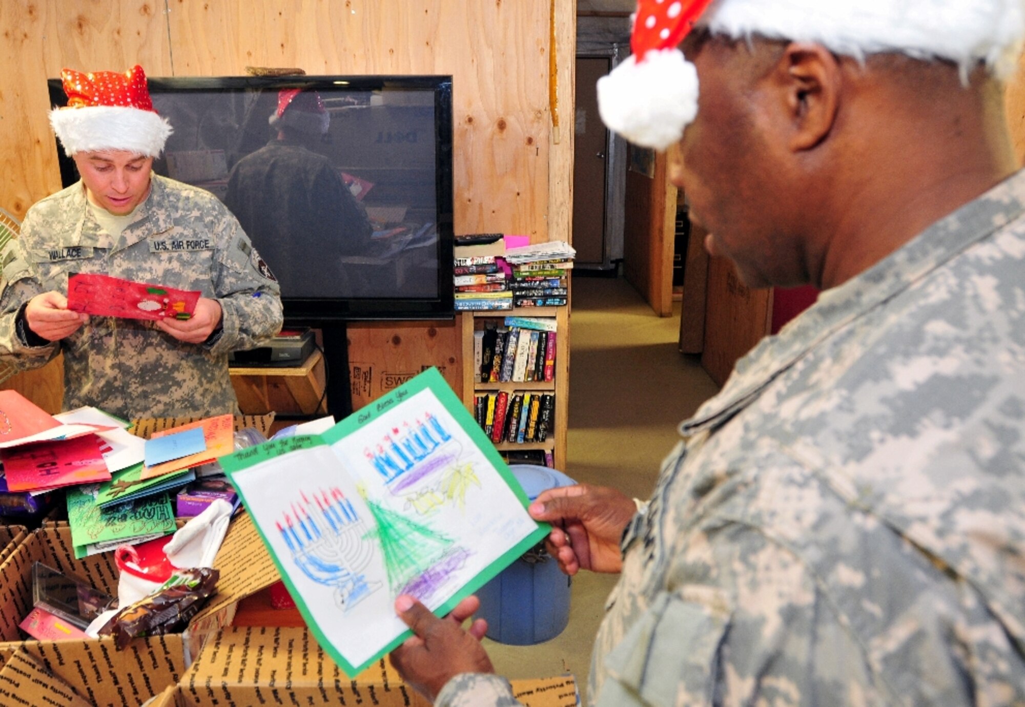 Army Sgt. Maj. Ira Turner (right) and Tech. Sgt. Kevin Wallace read Holiday cards sent to U.S. Forces-Afghanistan Detachment-West by students from Clifton, N.J., Dec. 21. Students, ranging from elementary school through pre-school, sent dozens of hand-crafted cards with personalized messages. (U.S. Navy photo/Petty Officer 1st Class John Pearl)