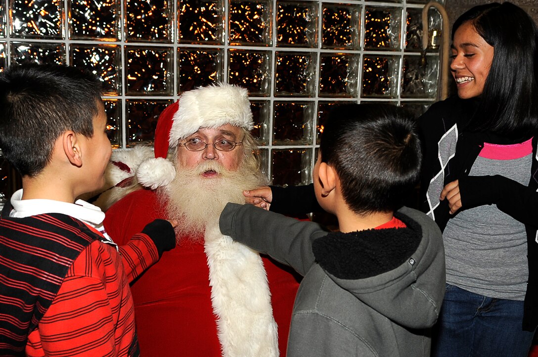 The Rivera family make a promise on Santa's beard to behave for the Holidays.  Children at the Deployed Spouses Holiday Party Dec. 17, 2010. were able to meet Santa as well as recieve a gift from his elves. (U.S. Air Force photo by/ Master Sgt. Jeromy K. Cross)
