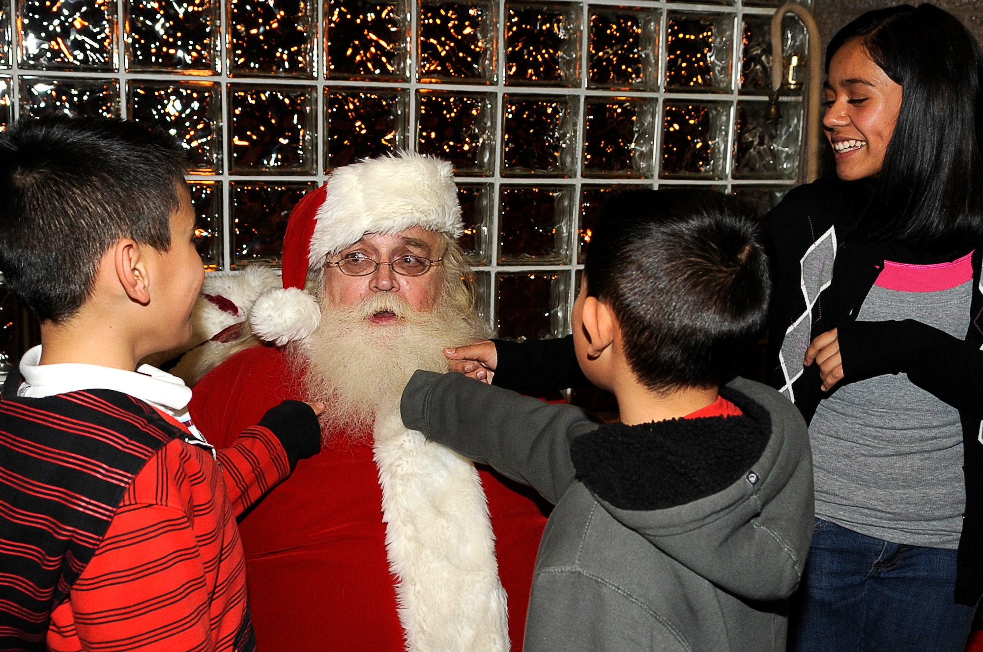 The Rivera family make a promise on Santa's beard to behave for the Holidays.  Children at the Deployed Spouses Holiday Party Dec. 17, 2010. were able to meet Santa as well as recieve a gift from his elves. (U.S. Air Force photo by/ Master Sgt. Jeromy K. Cross)
