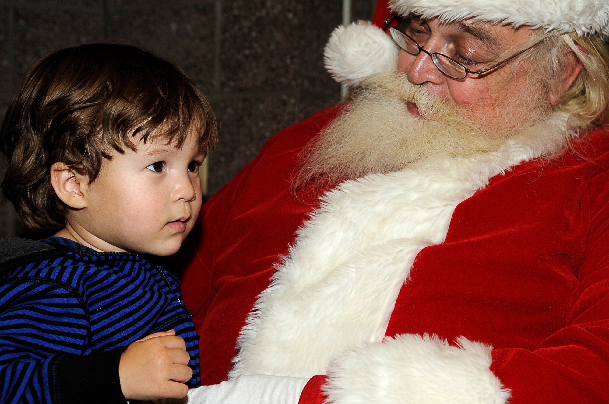 Benjamin Osterhouse sits with Santa at the Deployed Spouses Holiday Party Dec. 17, 2010. Familes were also treated to a dinner from Mimi's Cafe courtesy of the Salvation Army. (U.S. Air Force photo by Master Sgt. Jeromy K. Cross)
