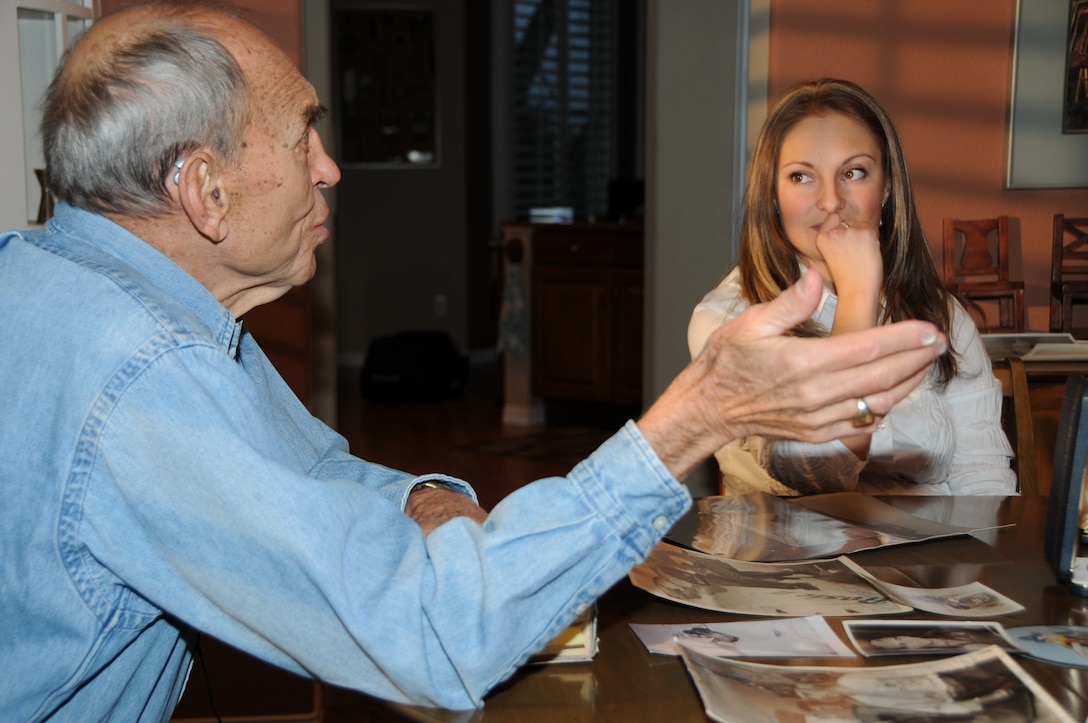 Kathryn Evezich, a sophomore at the University of Colorado and officer candidate from Officer Selection Office Denver, listens as retired Marine Col. Robert C. Lehnert, a former fighter pilot, tells his story about being part of the “Lost Squadron” in World War II, while at Lehnert’s home Dec. 23, 2010.  A film crew from Connecticut is producing a documentary about Marine Fighting Squadron 422 and the accident that occurred on Jan. 25, 1944, when the squadron lost 22 of 23 planes over the Pacific Ocean.