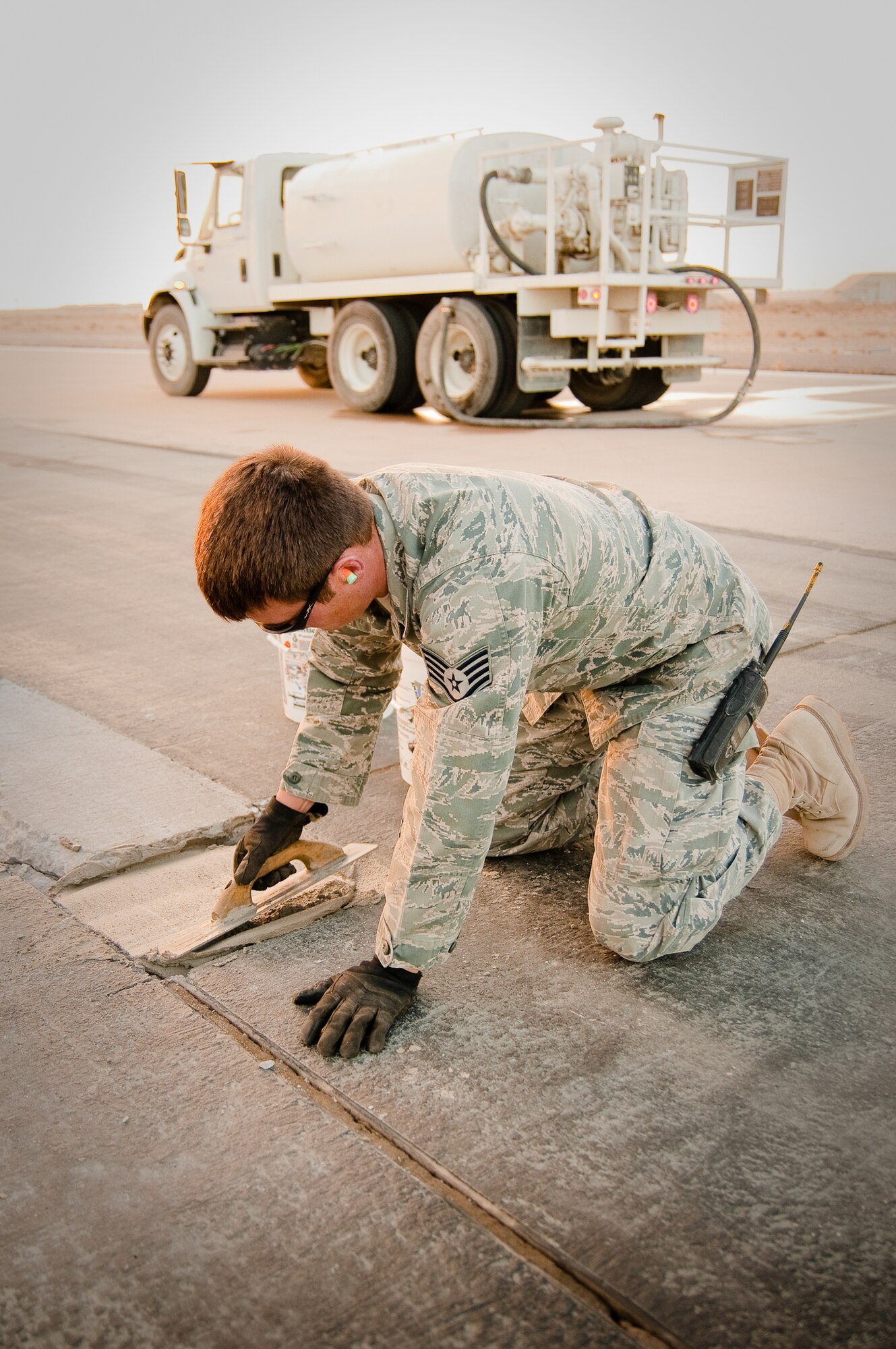 SOUTHWEST ASIA - Staff Sgt. Brandon Terhune of the 386th Expeditionary Civil Engineer Squadron uses a trowel to smooth out a mortar repair on one of the runways at an undisclosed air base here Dec. 10, 2010. Sergeant Terhune and his coworkers have poured more than 180 cubic feet of fresh mortar in the past six months to repair crumbling runways. (U.S. Air Force photo by Maj. Dale Greer)