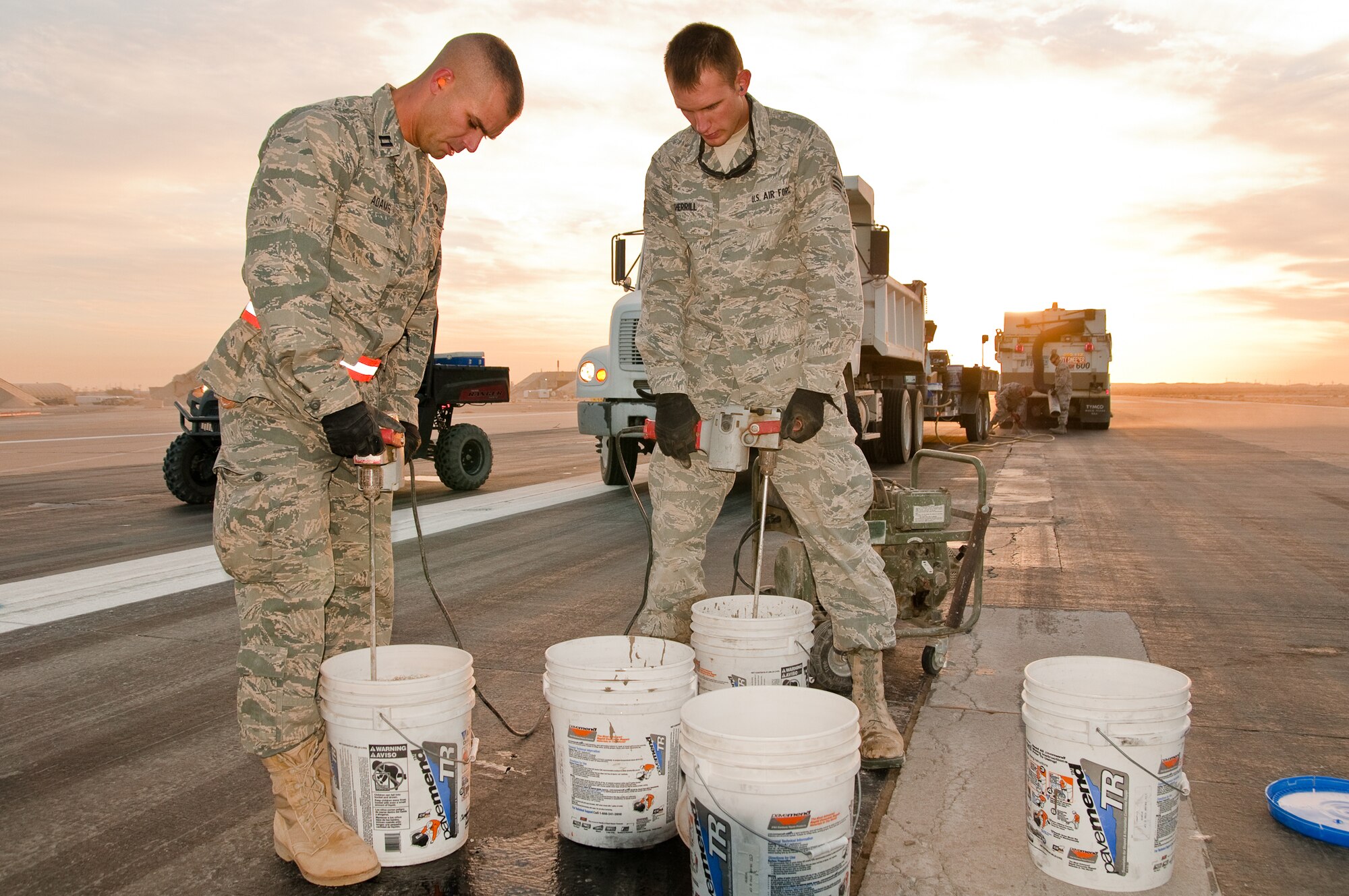 SOUTHWEST ASIA - Capt. Jason Adams (left) and Senior Airman John Sherrill of the 386th Expeditionary Civil Engineer Squadron mix rapid-setting mortar Dec. 10, 2010, for use in runway repairs at the 386th Air Expeditionary Wing. The repairs will prevent decaying concrete from causing damage to aircraft during takeoffs and landings at an undisclosed air base here. (U.S. Air Force photo by Maj. Dale Greer)