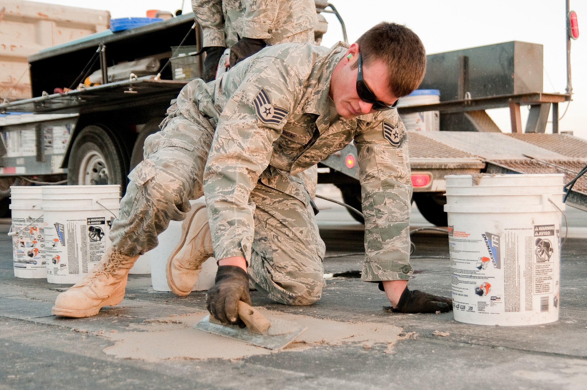 SOUTHWEST ASIA - Staff Sgt. Brandon Terhune of the 386th Expeditionary Civil Engineer Squadron smoothes out a fresh runway patch an undisclosed air base here Dec. 10, 2010. Sergent Terhune and his coworkers in the 386th CES have made hundreds of runway repairs since deploying here six months ago. (U.S. Air Force photo by Maj. Dale Greer)