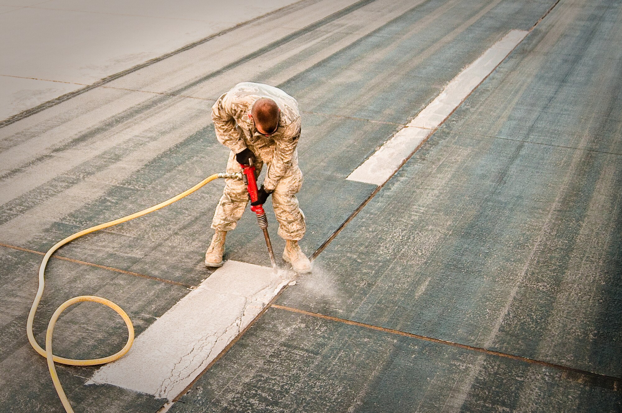 SOUTHWEST ASIA - Senior Airman Jacob Cleer, a heavy equipment operator assigned to the 386th Expeditionary Civil Engineer Squadron, uses a jackhammer Dec. 10, 2010, to excavate a section of crumbling concrete on one of the runways at the 386th Air Expeditionary Wing. The squadron conducts weekly runway repairs to prevent damage to aircraft from foreign object debris, or FOD. (U.S. Air Force photo by Maj. Dale Greer)