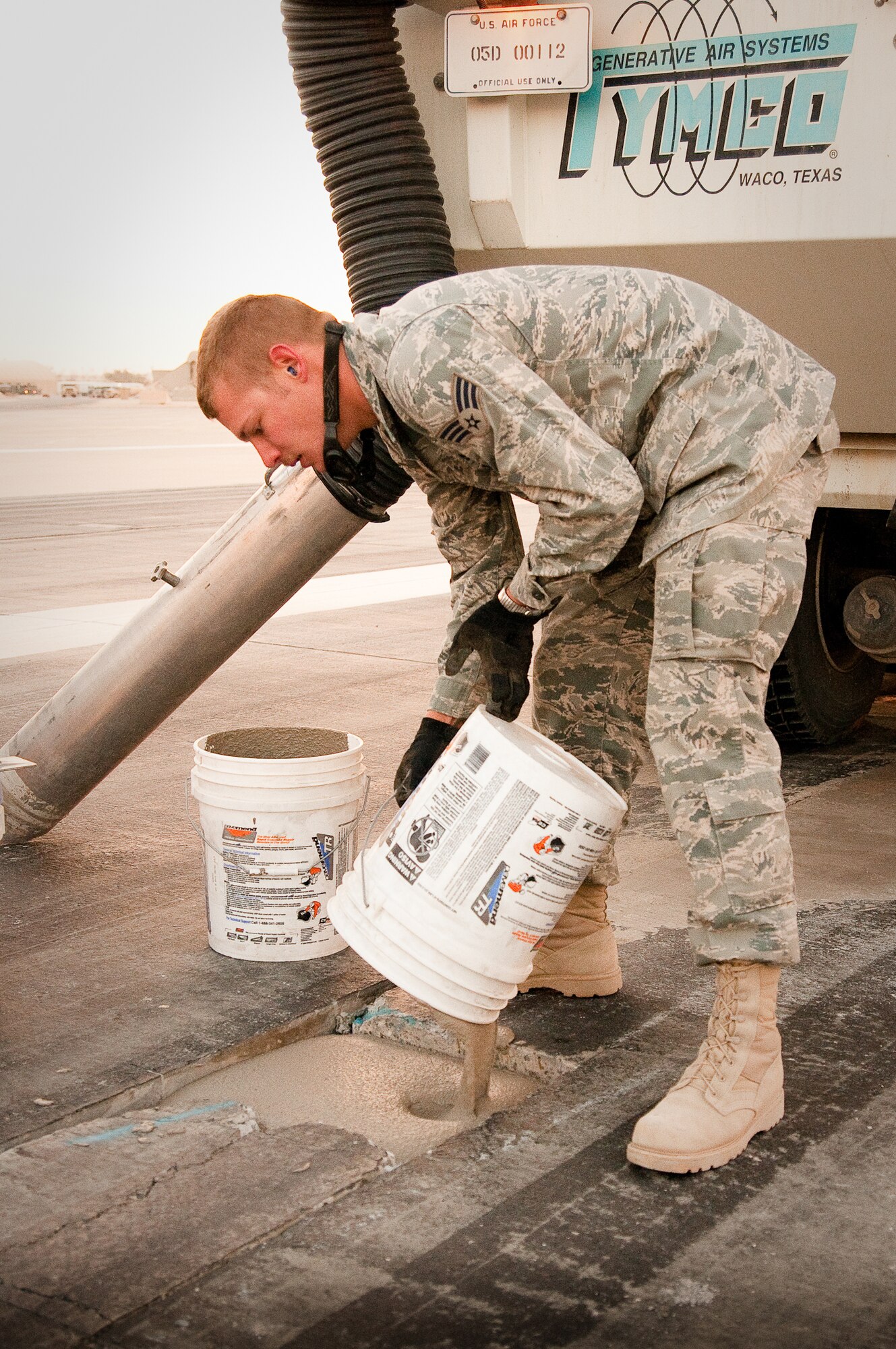 SOUTHWEST ASIA - Senior Airman Matthew Pezley of the 386th Expeditionary Civil Engineer Squadron patches a damaged runway at an undisclosed air base here with rapid-setting mortar Dec. 10, 2010. Airman Pezley was conducting weekly maintenance as part of the 386th Expeditionary Civil Engineer Squadron's Runway Repair Team. (U.S. Air Force photo by Maj. Dale Greer)