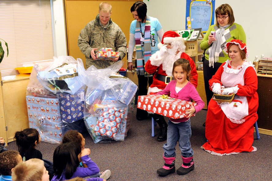Santa and Mrs. Claus hand out gifts donated by various organizations from Ellsworth Air Force Base, S.D. to children at the Youth & Family Services Child Care program in Rapid City, S.D., Dec. 16.  YFS is the largest human services organization of its kind in western South Dakota, providing comprehensive services to more than 11,000 children, infant through teens, and their families through seven programs under the YFS umbrella. (U.S. Air Force photo/Staff Sgt. Marc I. Lane)