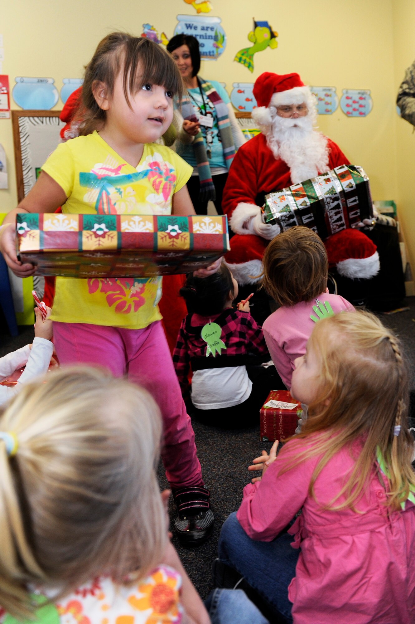 Santa and Mrs. Claus hand out gifts donated by various organizations from Ellsworth Air Force Base, S.D. to children at the Youth & Family Services Child Care program in Rapid City, S.D., Dec. 16.  YFS is the largest human services organization of its kind in western South Dakota, providing comprehensive services to more than 11,000 children, up to age 18, and their families through seven programs under the YFS umbrella. (U.S. Air Force photo/Staff Sgt. Marc I. Lane)