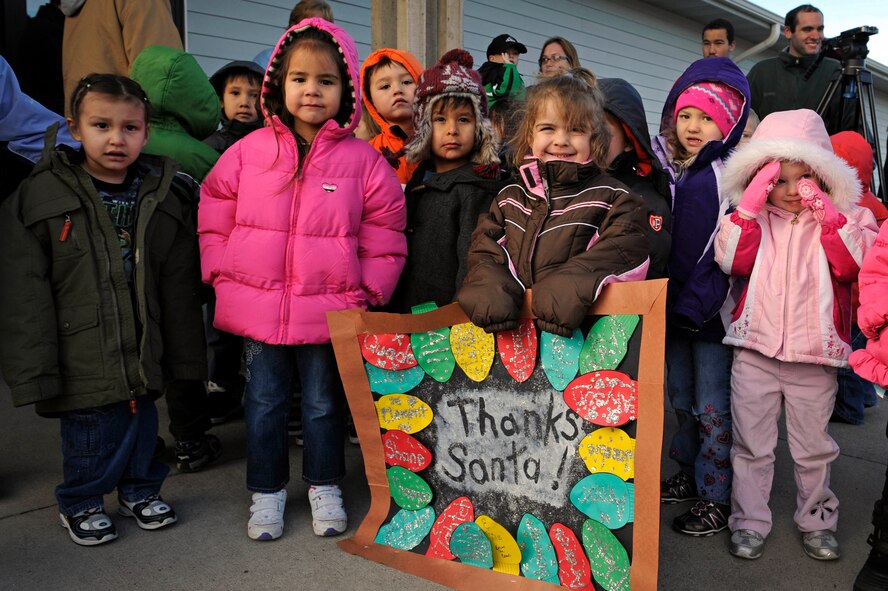 Children from the Youth & Family Services Child Care Bears classroom stand in front of the sign they made for Santa, Dec. 16.  Santa, Mrs. Claus, and roughly 30 volunteers from the base assisted in delivering toys as part of the 28th Operations Group Angel Tree Program. (U.S. Air Force photo/Staff Sgt. Marc I. Lane)