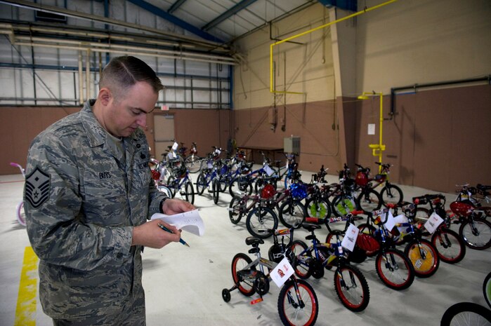 NELLIS AIR FORCE BASE, Nev. -- Master Sgt. Joel Buys, 763rd Maintenance Squadron first sergeant, checks inventory of bicycles before delivery Dec. 20. Océ, a technology and services company, assembled more than 80 bikes during a team-building exercise and donated them to Nellis and Creech. First sergeants identified and delivered the bikes to young Airmen and their families at both bases who could best benefit from the donation. (U.S. Air Force photo by Senior Airman Brett Clashman/Released)