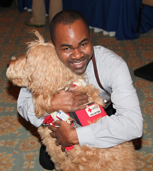 Major Klavens Noel, a chaplain for the 911th Airlift Wing, hugs "Gus" a comfort dog provided by the American Red Cross during the Yellow Ribbon event held December 18 and 19, 2010 at Nemacolin Woodlands Resort located in Farmington, Pa.  Comfort dogs are provided by the Red Cross to bring emotional relief in times of stress for our Airmen.