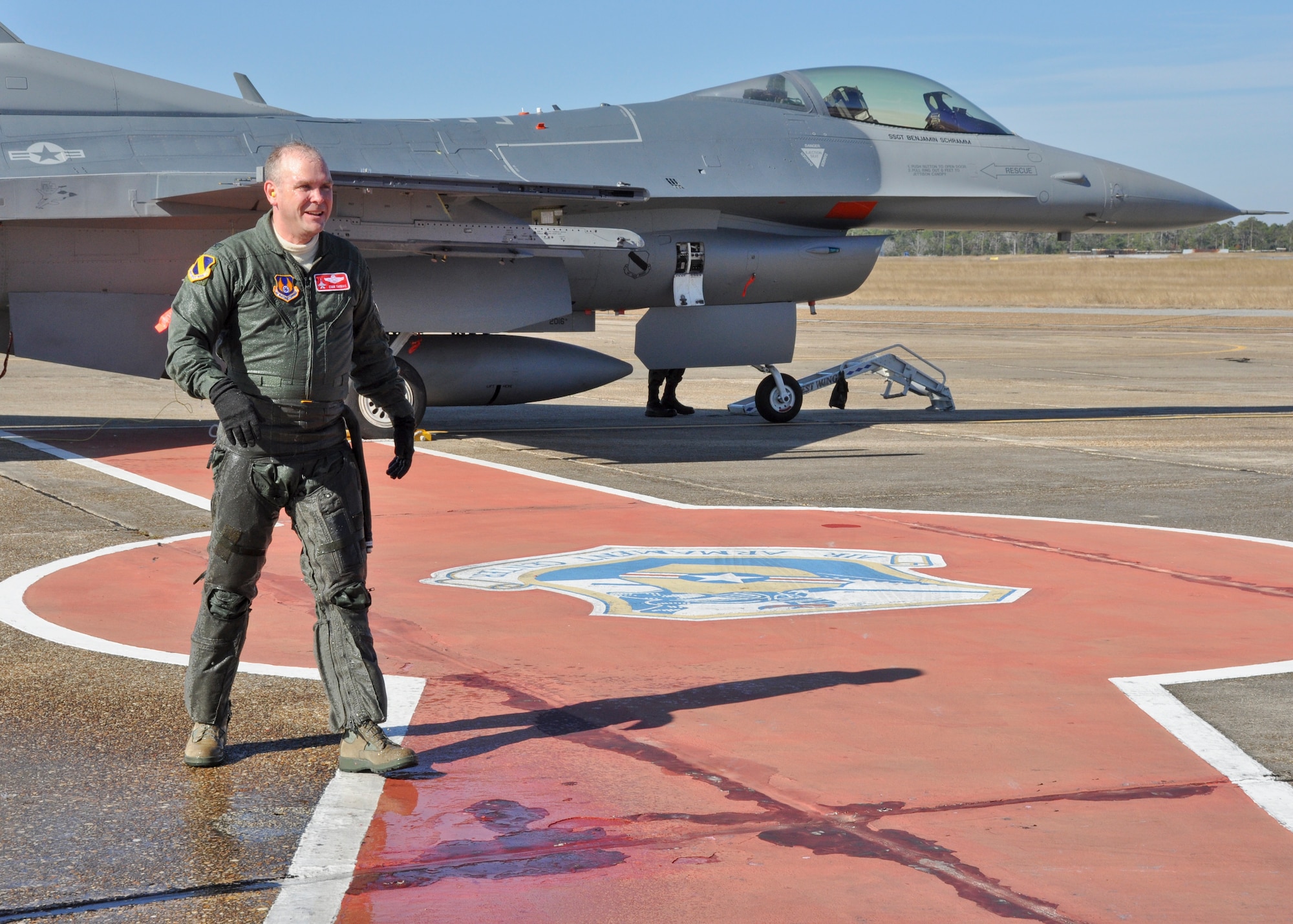 EGLIN AIR FORCE BASE, Fla. - Col. Evan Thomas, 46th Test Wing vice commander, walks toward the crowd waiting to congratulate him on his "fini flight" at Base Operations on Eglin’s flight line. Shortly after the colonel landed for the last time here, his family greeted him with the traditional Air Force spray down using a fire hose, compliments of an Eglin Fire and Emergency Services vehicle nearby. Colonel Thomas is retiring from the Air Force and the wing expects a replacement in June. (U.S. Air Force photo/Chrissy Cuttita)